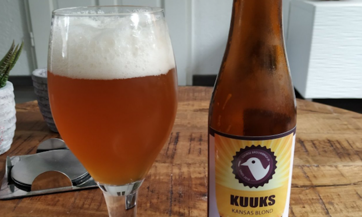 KUUKS Kansas Blond gevuld glas en een flesje op tafel